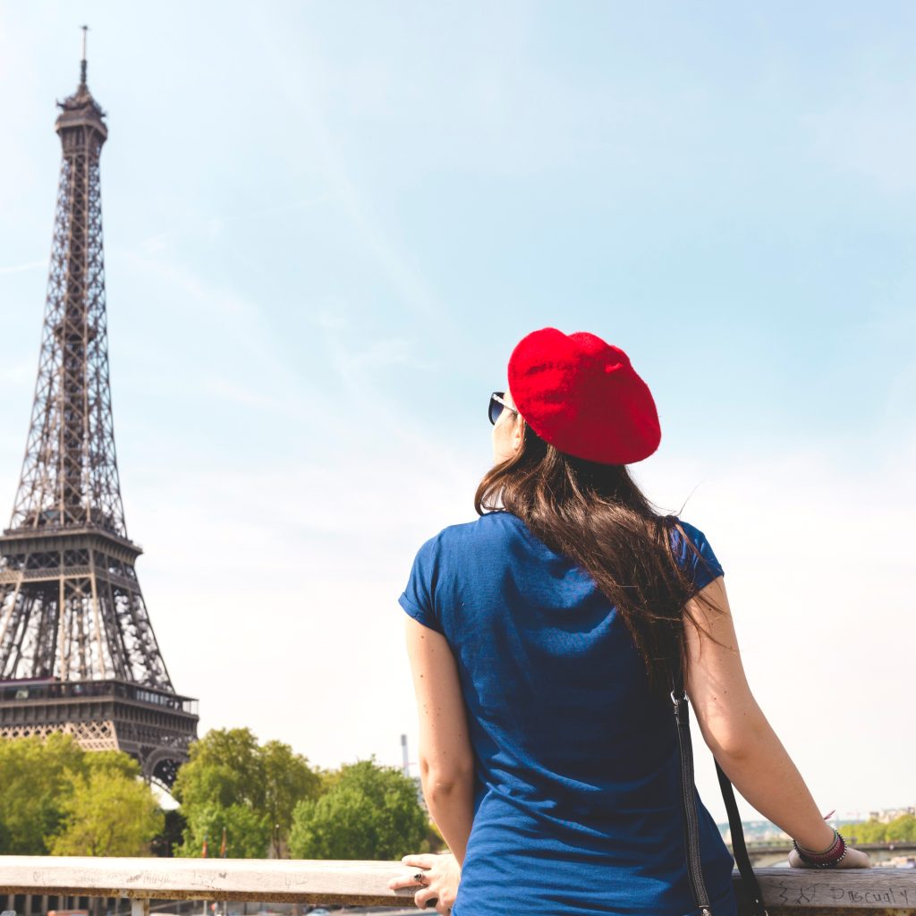 Woman in red beret looking at the Eiffel Tower (Paris) in the distance